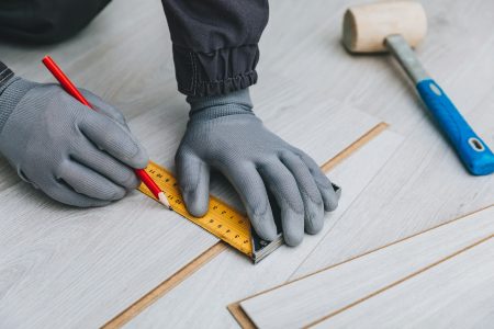 Worker installing new laminated wooden floor